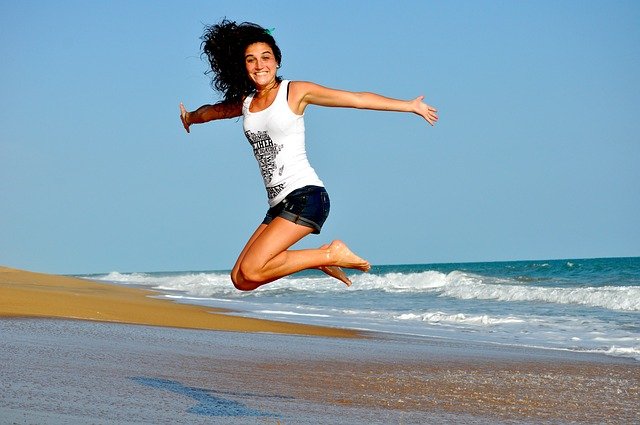 A person jumping on a beachDescription automatically generated with medium confidence
