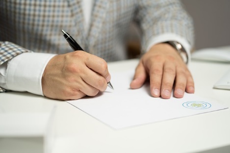 A person writing on a piece of paper

Description automatically generated with medium confidence